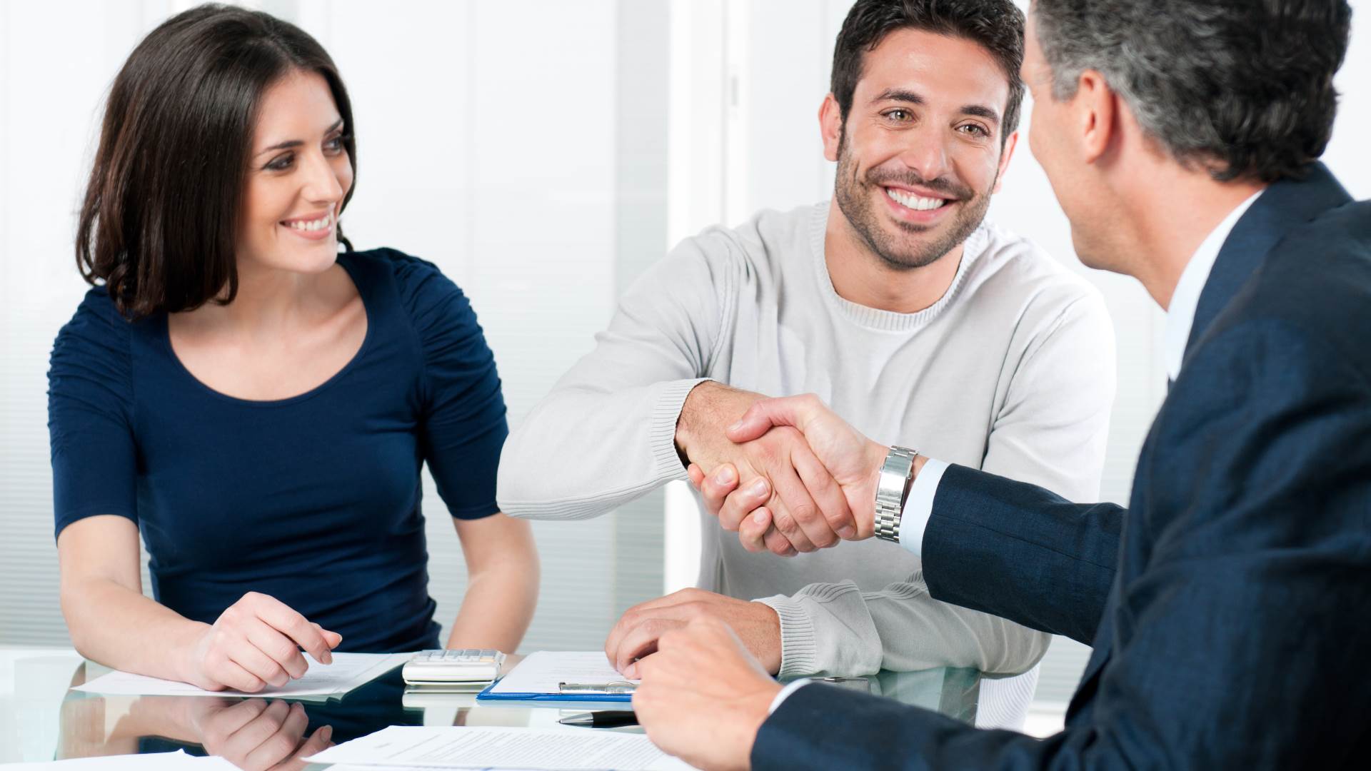 Couple shaking hands with a Loan officer